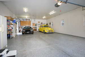 Garage featuring freestanding refrigerator and a garage door opener