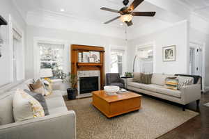 Living area with plenty of natural light, a tile fireplace, recessed lighting, a ceiling fan, and wood finished floors