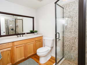 Bathroom with vanity, a stall shower, and light wood-style floors