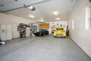 Garage featuring white fridge with ice dispenser and a garage door opener