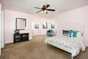 Carpeted bedroom featuring a ceiling fan and baseboards