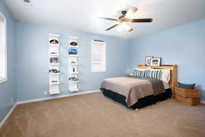 Bedroom with a ceiling fan and carpet flooring