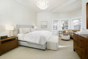 Bedroom featuring light colored carpet, suspended lighting, and beam ceiling