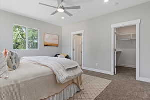 Bedroom featuring light carpet, a spacious closet, a ceiling fan, and recessed lighting