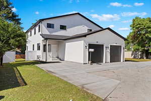 Modern inspired farmhouse with an attached garage, stucco siding, driveway, and a gate