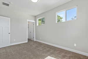 Unfurnished bedroom with a walk in closet and carpet