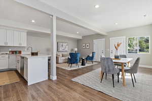 Dining space with dark wood-type flooring, beamed ceiling, and recessed lighting