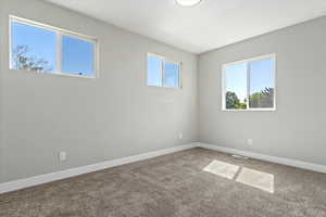 Unfurnished room with plenty of natural light and carpet
