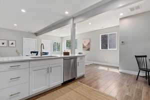 Kitchen featuring white cabinetry, dishwasher, light wood-style flooring, light stone countertops, and recessed lighting