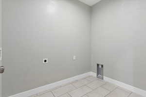 Laundry area featuring hookup for an electric dryer and light tile patterned floors