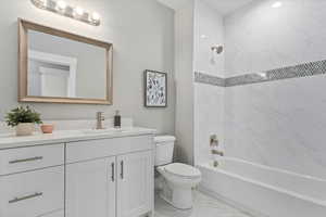 Bathroom with vanity, shower / bath combination, and light marble finish floors