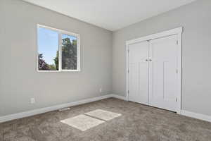 Unfurnished bedroom featuring carpet and a closet