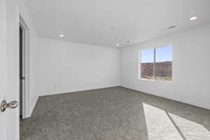 Unfurnished room featuring dark colored carpet and recessed lighting