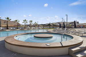 Community pool with a patio area and a community hot tub
