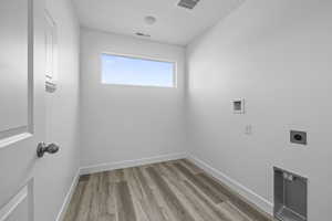 Laundry area with light wood-style flooring, washer hookup, and electric dryer hookup