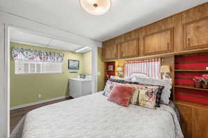 Bedroom with washer / clothes dryer and dark wood-type flooring