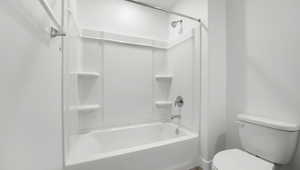 Bathroom featuring toilet and shower / tub combination