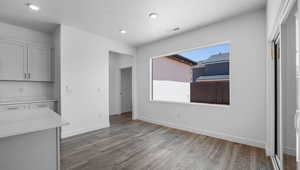 Unfurnished dining area with dark wood-style floors and recessed lighting