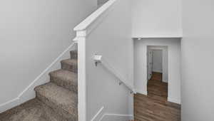 Stairway featuring a high ceiling and wood finished floors