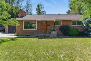 Ranch-style home with a front lawn, brick siding, and a shingled roof
