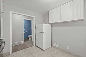 Laundry area with light tile patterned flooring