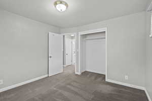 Unfurnished bedroom with carpet floors and a closet