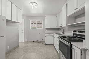 Kitchen with stainless steel range with electric cooktop, white cabinetry, freestanding refrigerator, and open shelves