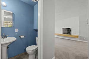 Half bathroom featuring a fireplace and carpet flooring