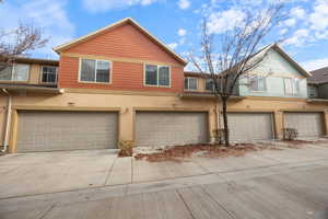 Traditional-style house featuring an attached 2 car garage, concrete driveway, and stucco siding