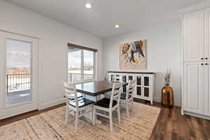 Semi-formal dining space with recessed lighting and LVP flooring, featuring access to back covered deck