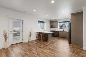 Basement second kitchen featuring LVP flooring, black stainless steel appliances, and quartz countertops, along with patio walkout