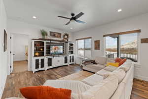 Open concept living area with ceiling fan, recessed lighting, LVP floors, and 9' ceilings.