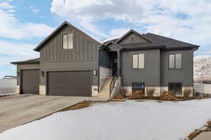 View of front of house with a mountain view, board and batten Hardie siding, a garage, and driveway