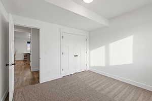 Basement spare bedroom featuring carpet floors, light paint, daylight window and ceiling fan