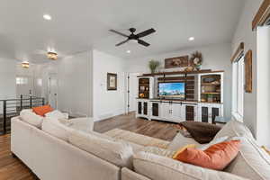 Open concept living area with ceiling fan, recessed lighting, LVP floors, and 9' ceilings.