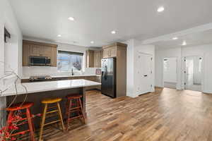 Basement second kitchen featuring LVP flooring, black stainless steel appliances, and quartz countertops