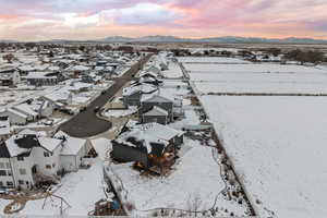 Snowy aerial view with mountain backdrop