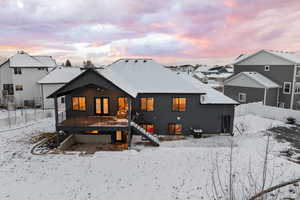 Snow covered property with a covered deck and patio area