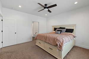 Primary bedroom with light carpet, ceiling fan, and recessed lighting