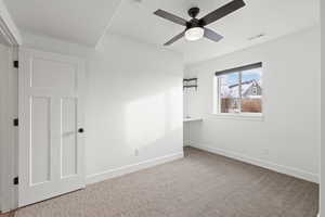 Basement spare bedroom featuring carpet floors, light paint, daylight window and ceiling fan