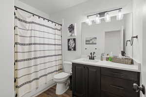 Basement full bathroom featuring tub/shower combination, LVP flooring, dark cabinets and light quartz counters