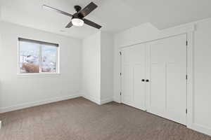 Basement spare bedroom featuring carpet floors, light paint, daylight window and ceiling fan