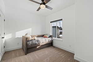 Main floor spare bedroom with carpeted floors, light paint, ceiling fan and natural light