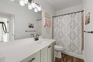 Main floor full bathroom featuring tub/shower combo, large vanity with quartz counters, and LVP flooring