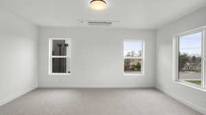Photos are of a completed unit - Unfurnished room featuring light carpet and baseboards