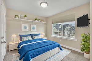 Bedroom featuring light colored carpet and baseboards