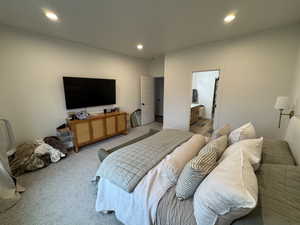 Bedroom with light carpet, recessed lighting, and connected bathroom