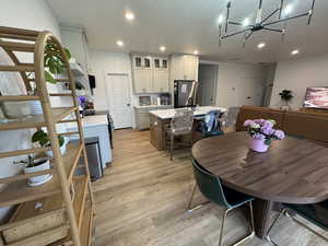 Dining space featuring light wood-style floors and hanging lights