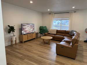Living area featuring wood finished floors and recessed lighting