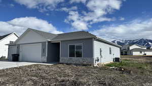 View of front of house with an attached garage, stone siding, a mountain view, concrete driveway, and a shingled roof